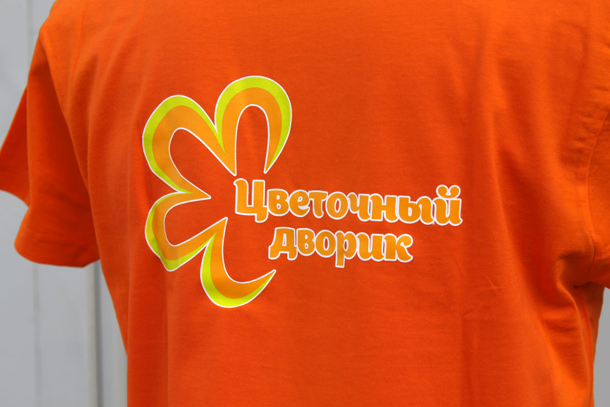 Увеличенная Фотография фрагмента оранжевой футболки с логотипом Цветочный дворик на спине