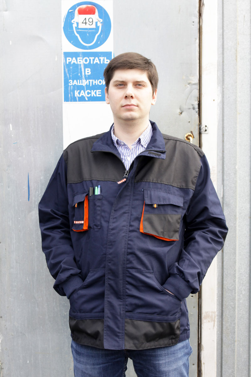 Фотография куртки ЭМЕРТОН НЭВИ на фоне строительной бытовки